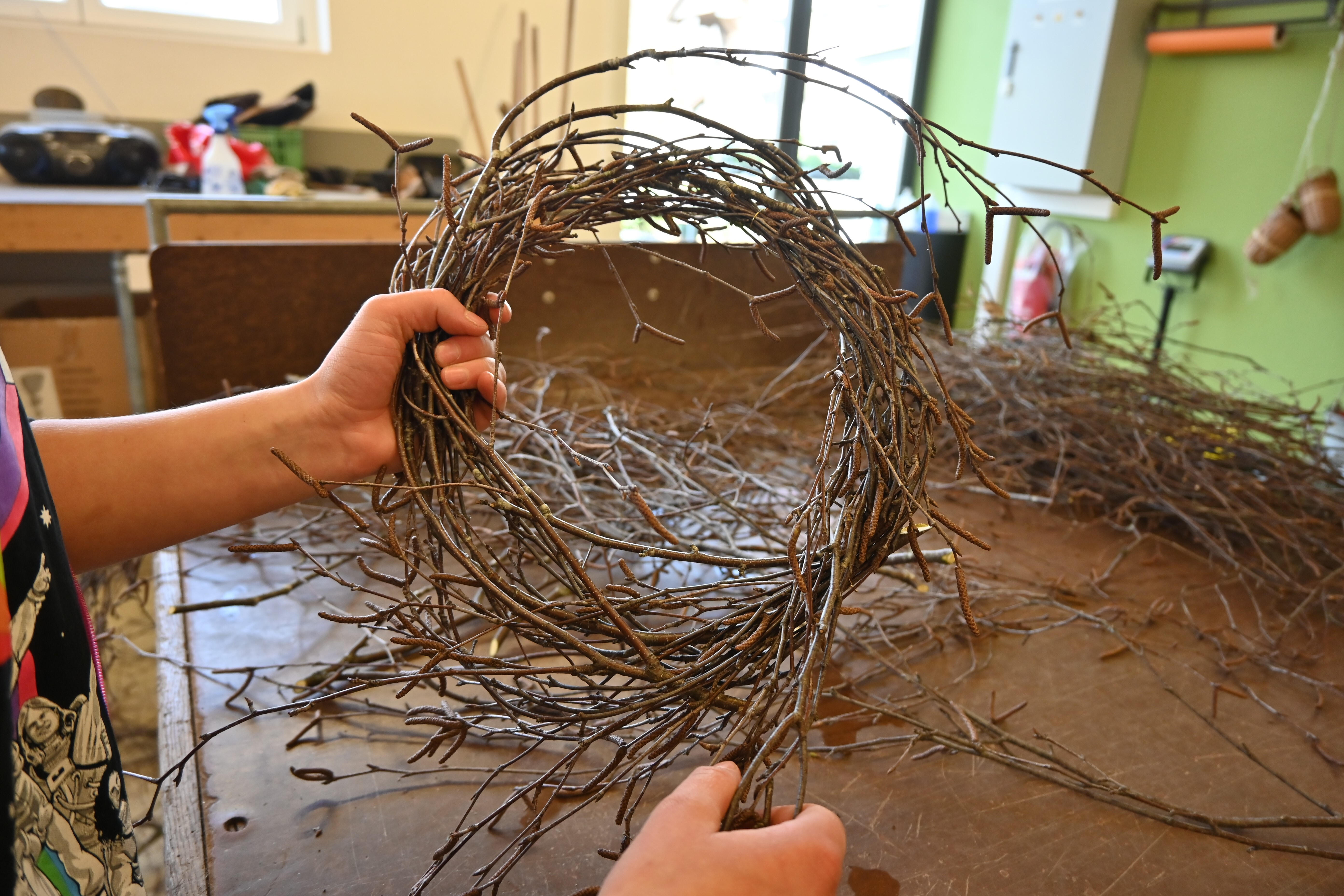 Die Birkenaeste werden zu einem Kranz gebunden